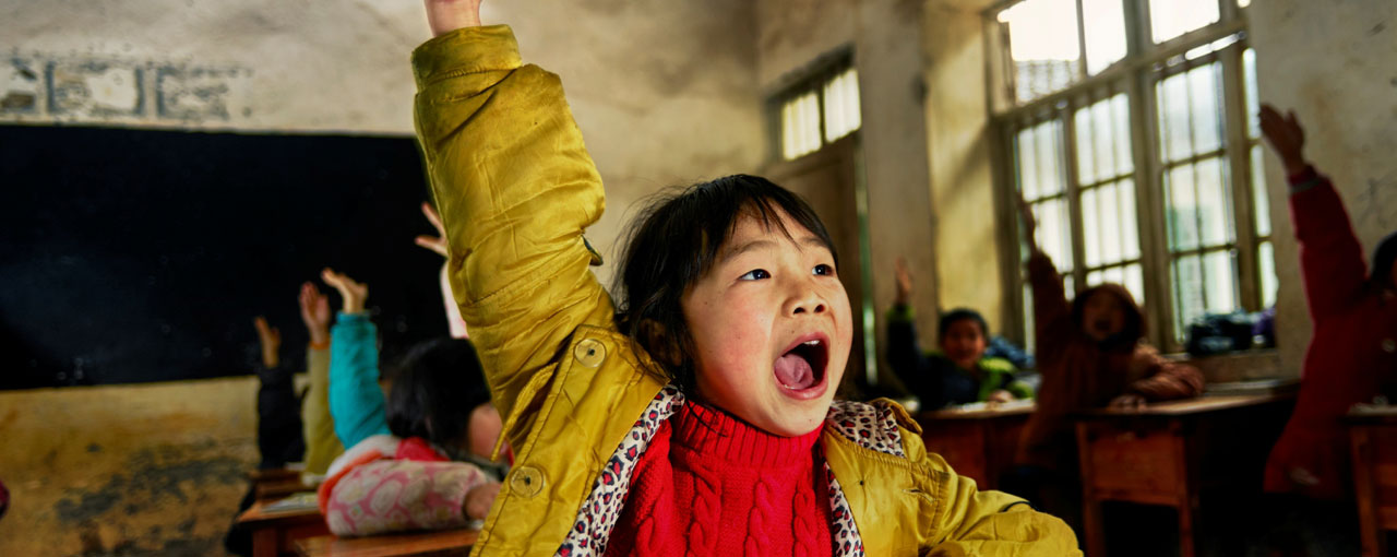 Young girl raising her hand